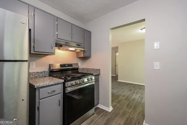 a kitchen with stainless steel appliances granite countertop a stove and a refrigerator