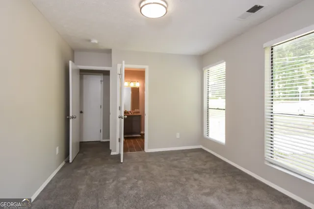 an empty room with windows and closet