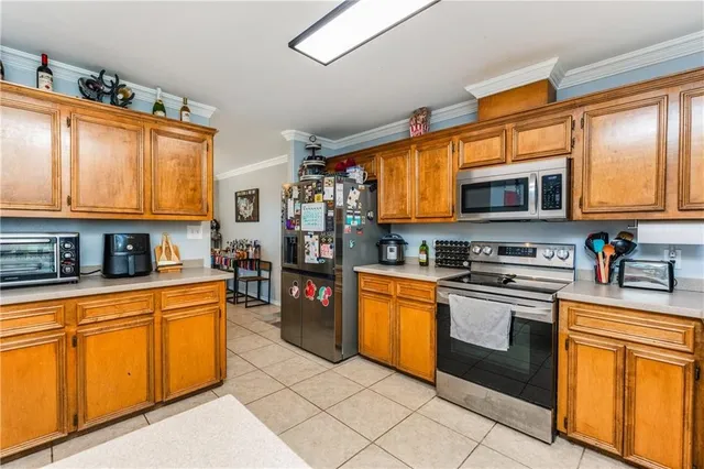 a kitchen with stainless steel appliances granite countertop a stove top oven a sink dishwasher a dining table and chairs with wooden floor