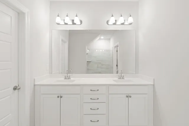 a bathroom with a double vanity sink and a mirror