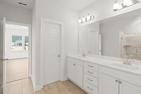 a spacious bathroom with a double vanity sink and a mirror