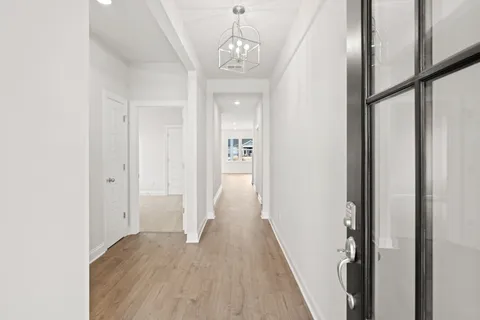 a view of a hallway with wooden floor and staircase