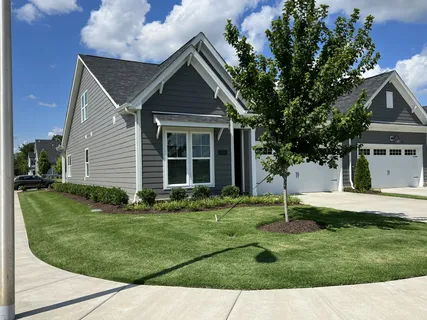 a front view of a house with a yard and outdoor seating