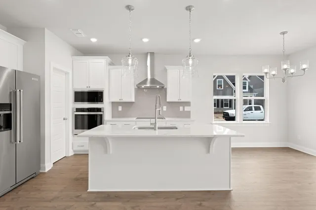 a large kitchen with kitchen island a sink stainless steel appliances and cabinets