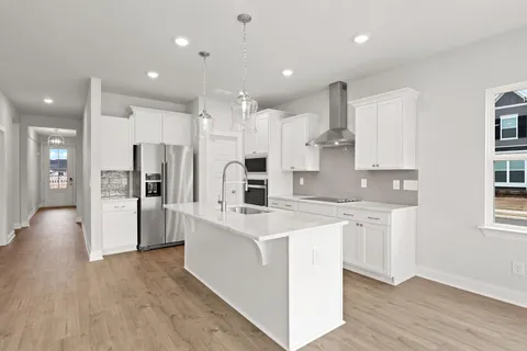a kitchen with stainless steel appliances kitchen island a refrigerator sink and cabinets