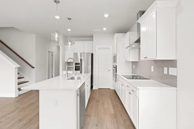a large white kitchen with stainless steel appliances