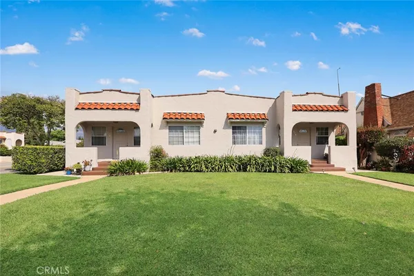 a front view of a building with a garden and plants
