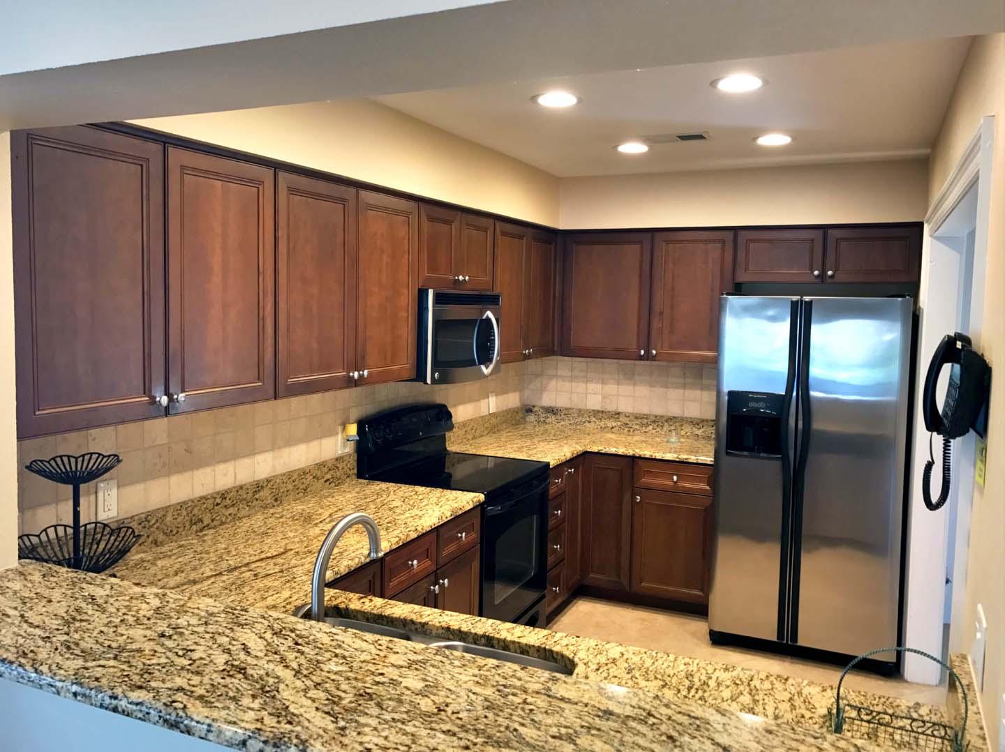 5073 Beachwalk Way Miramar Beach, FL 32550 - Photo 11 of 61 a kitchen with stainless steel appliances granite countertop a refrigerator a stove and a sink with wooden cabinets