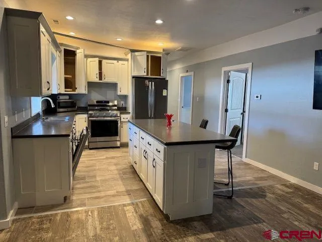 a kitchen with stainless steel appliances granite countertop a sink stove and refrigerator