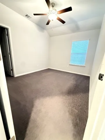 en empty room with an entryway and fan