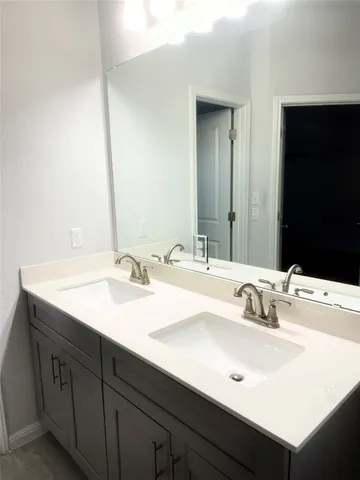 a bathroom with double sink and a mirror