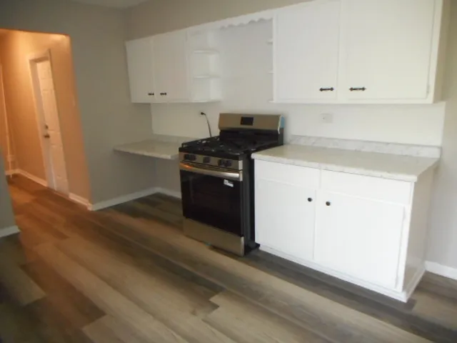 en empty room with wooden floor and windows