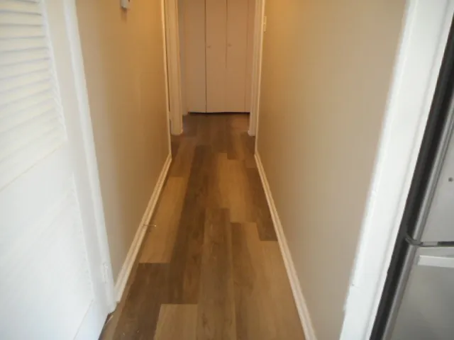 a view of a hallway with wooden floor