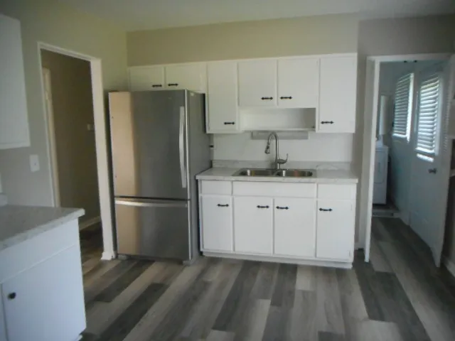 a kitchen with appliances a sink and cabinets