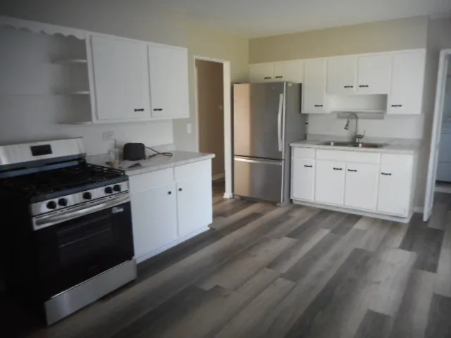 a kitchen with stainless steel appliances a refrigerator sink and cabinets