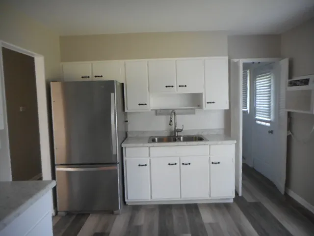 a kitchen with stainless steel appliances a stove and white cabinets