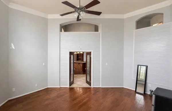 a view of an empty room with wooden floor and a window