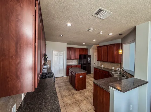 a kitchen with stainless steel appliances granite countertop a sink refrigerator and cabinets
