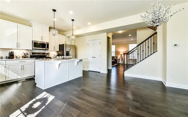 a kitchen with stainless steel appliances a stove top oven a sink cabinets and a wooden floor