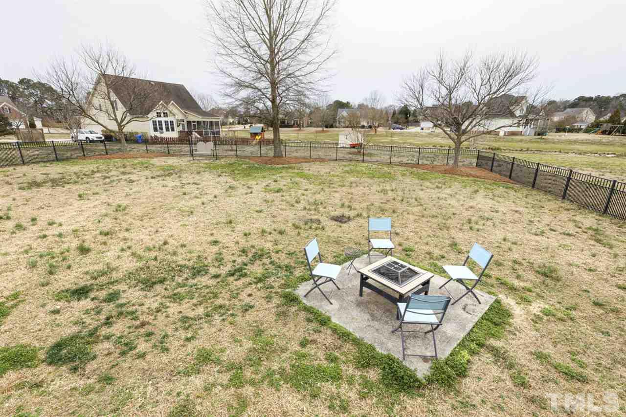 4609 Swordfish Drive Raleigh, NC 27603 - Photo 28 of 30 a view of a lake with a house and a yard with wooden fence