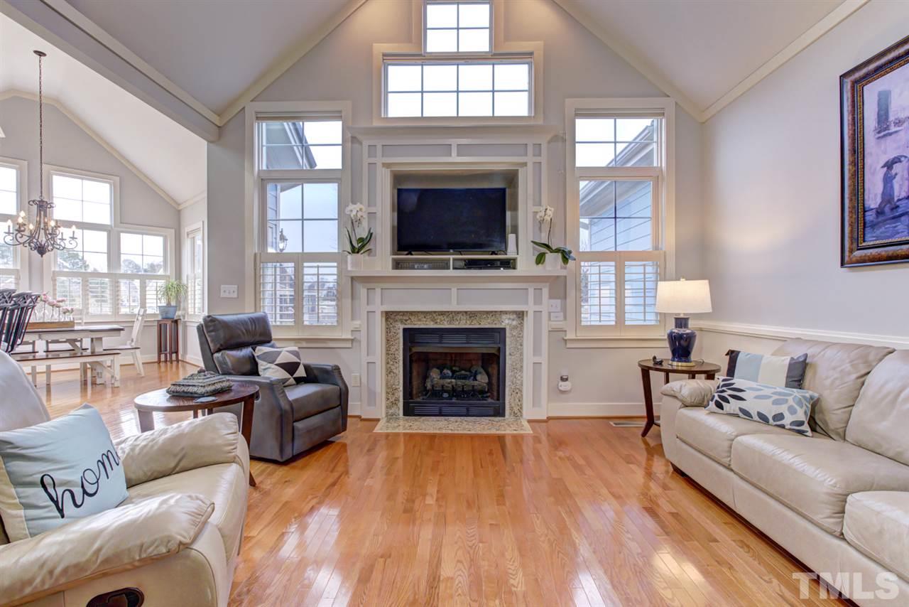 4609 Swordfish Drive Raleigh, NC 27603 - Photo 6 of 30 a living room with furniture a fireplace and a flat screen tv