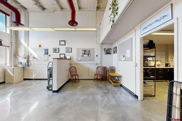 a view of a workspace with furniture and wooden floor