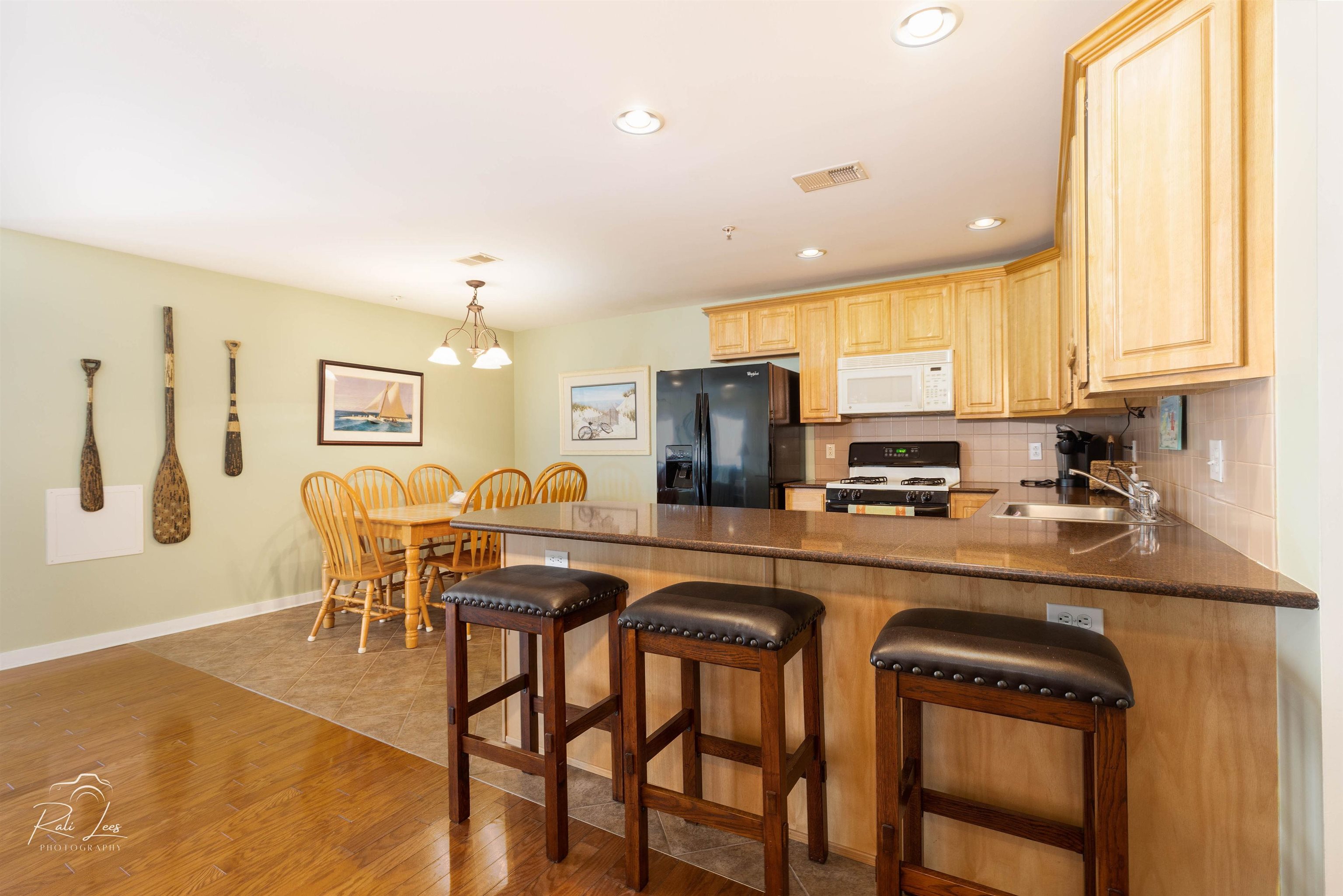 503 East Stanton Road, Unit 403 Wildwood Crest, NJ 08260 - Photo 15 of 42 a kitchen with stainless steel appliances granite countertop a table chairs refrigerator and microwave