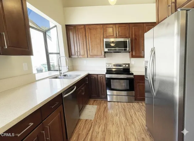 a kitchen with a sink a microwave a refrigerator and cabinets