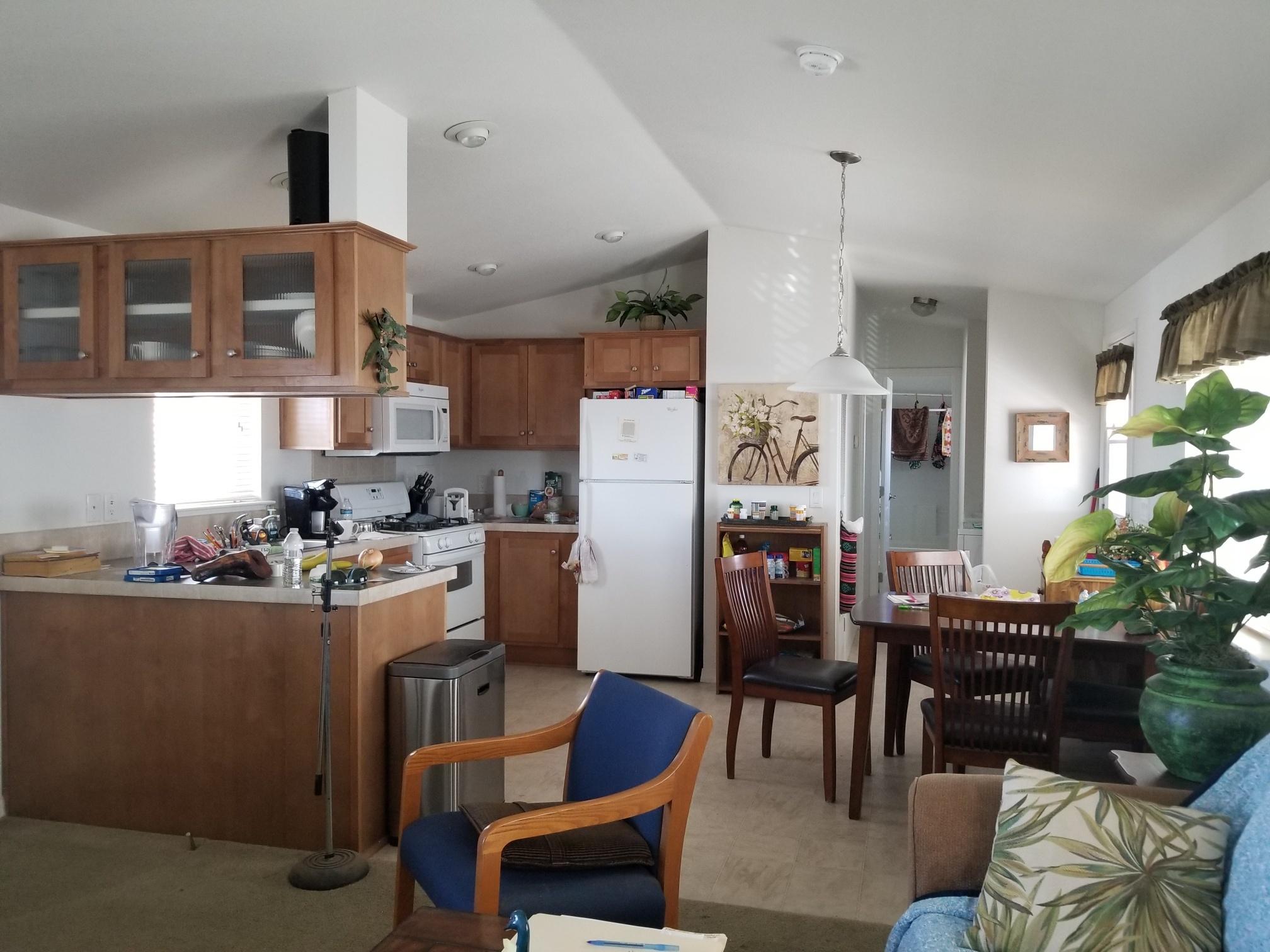 1500 Spa Road Niland, CA 92257 - Photo 3 of 24 a kitchen with stainless steel appliances kitchen island granite countertop a dining table chairs refrigerator and sink