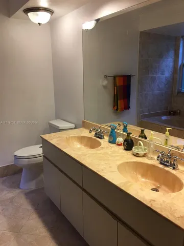 a bathroom with a granite countertop sink a toilet and a mirror