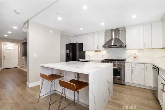 a kitchen with kitchen island white cabinets and stainless steel appliances