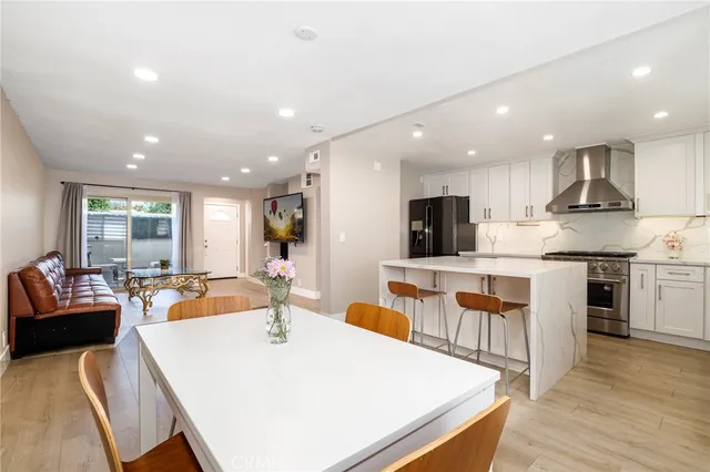 a large kitchen with kitchen island a stove a sink a dining table and chairs