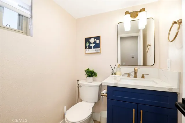 a bathroom with a sink vanity mirror and toilet