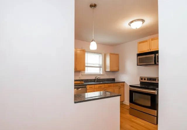 a kitchen with stainless steel appliances granite countertop a stove and a microwave