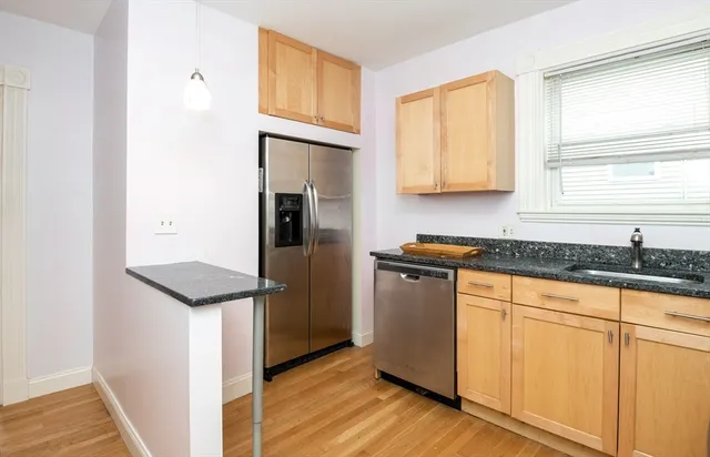 a kitchen with granite countertop a refrigerator and a sink