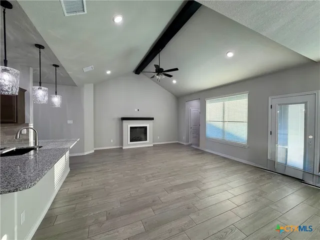 a view of an empty room with a fireplace and a window
