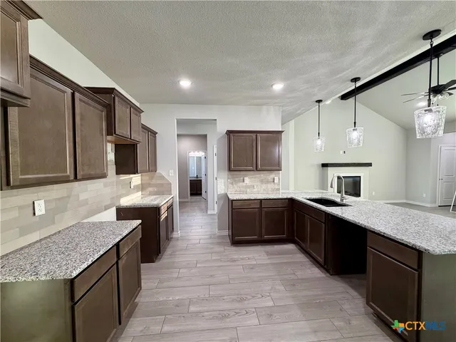 a large kitchen with granite countertop kitchen island a sink dishwasher stove and oven