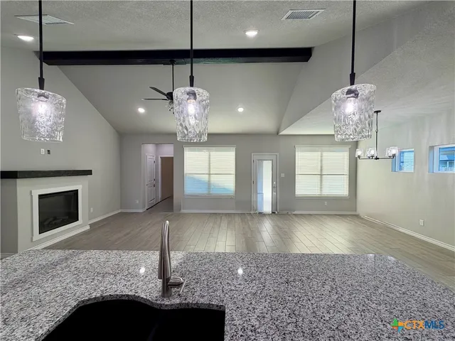 a view of a kitchen with a sink and chandelier