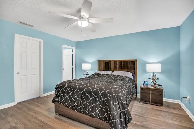 a bedroom with a bed and wooden floor