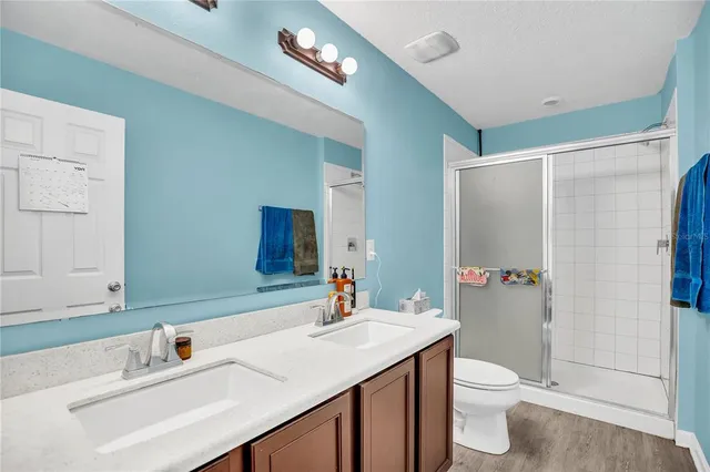 a bathroom with a sink toilet a mirror and shower