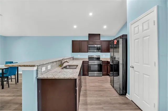 a kitchen with stainless steel appliances granite countertop a refrigerator stove microwave and sink