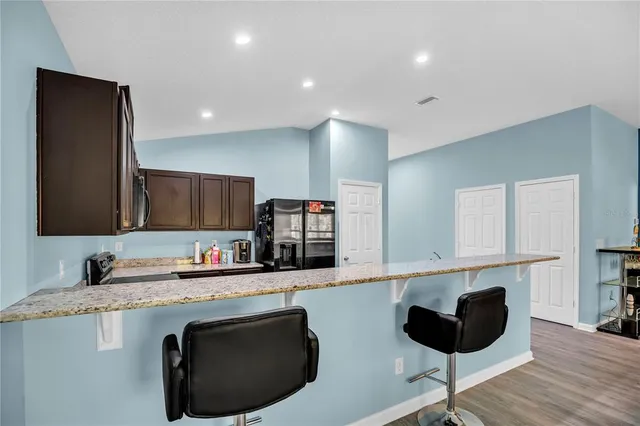 a kitchen with stainless steel appliances granite countertop a sink a stove a microwave a counter top and cabinets