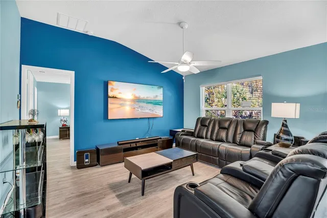 a living room with furniture a lamp and a flat screen tv