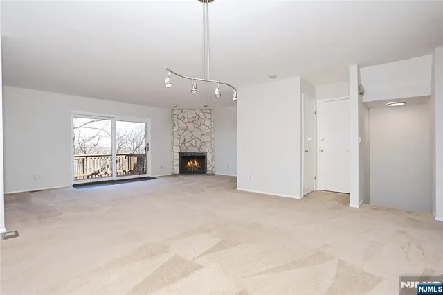 a view of an empty room with a fireplace and a window