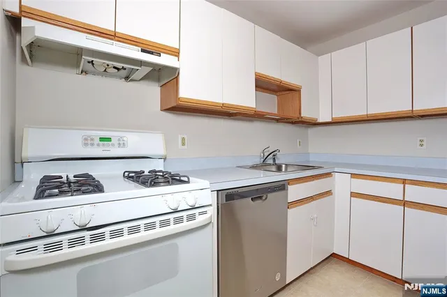 a white kitchen with a stove and a sink