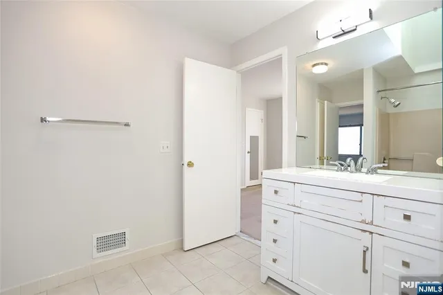 a spacious bathroom with a double vanity sink and mirror