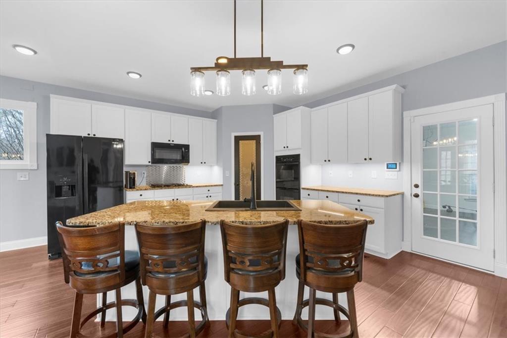 5488 Price Road Gainesville, GA 30506 - Photo 15 of 55 a kitchen with stainless steel appliances granite countertop a dining table chairs refrigerator and cabinets