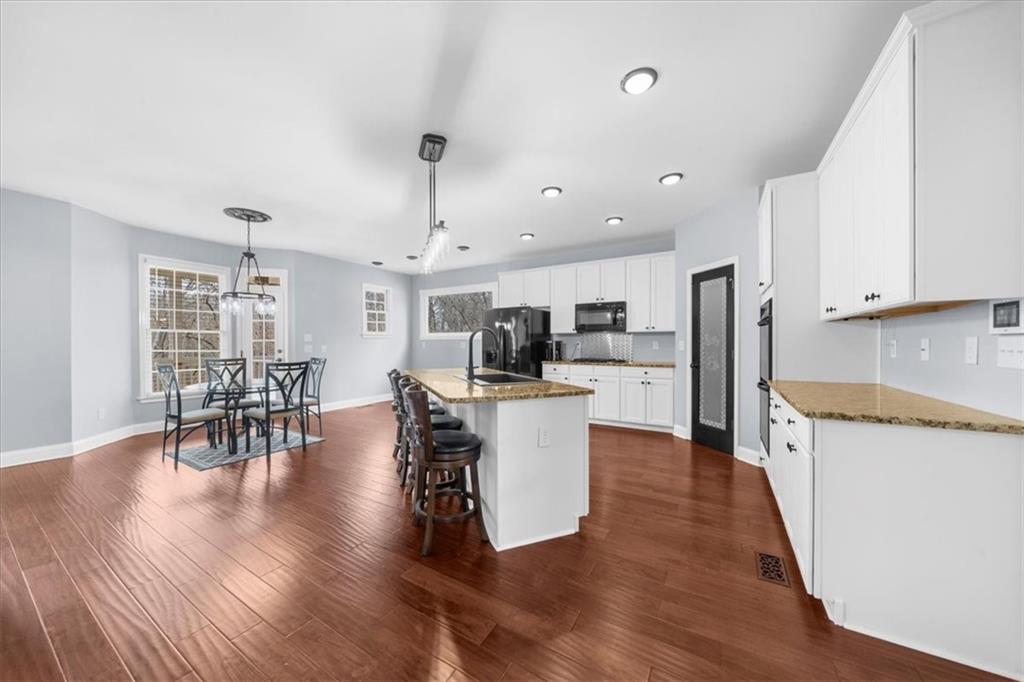 5488 Price Road Gainesville, GA 30506 - Photo 19 of 55 a kitchen with stainless steel appliances kitchen island wooden floors and white cabinets