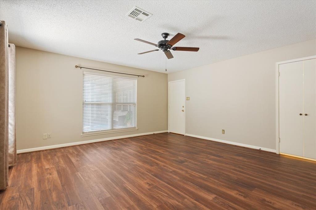 4108 Old Mill Road Waco, TX 76710 - Photo 21 of 39 Spacious primary bedroom room featuring warm wood-like vinyl flooring, ceiling fan, and natural light from multiple windows