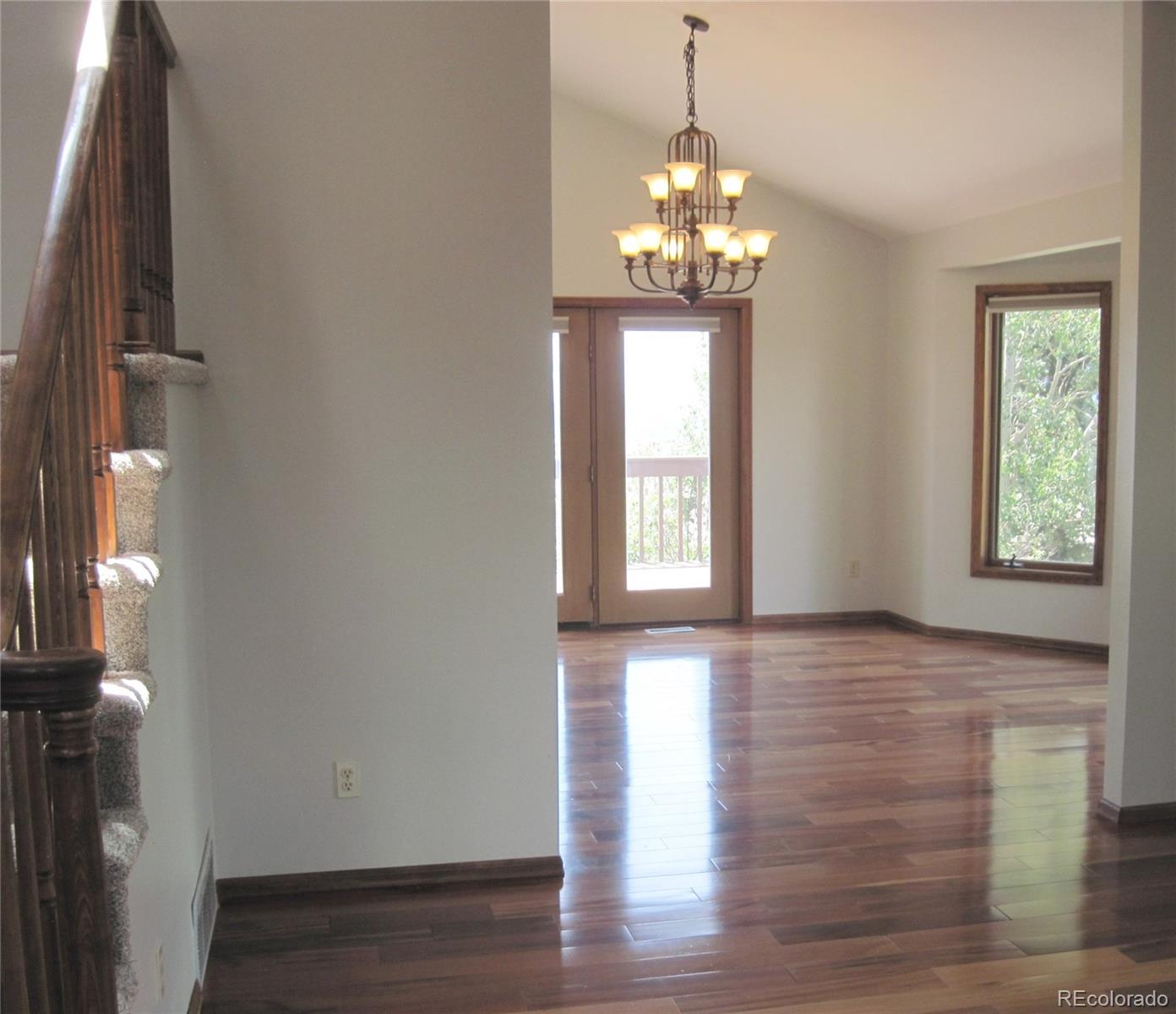 655 Harness Road Monument, CO 80132 - Photo 7 of 42 a view of an empty room with wooden floor and a window